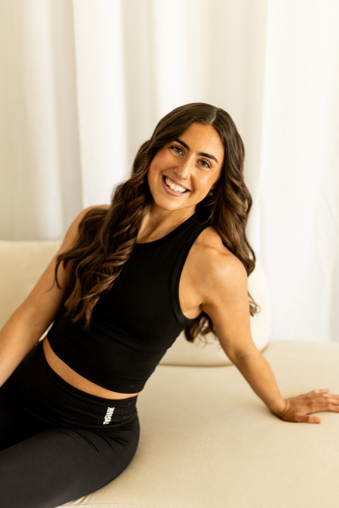 Merissa Erb smiling, seated on a cream sofa